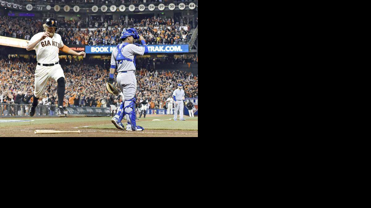 
San Francisco’s Hunter Pence leaped after scoring behind Royals catcher Salvador Perez in the sixth inning on a two-run single by Brandon Belt during Saturday's World Series game in San Francisco.
