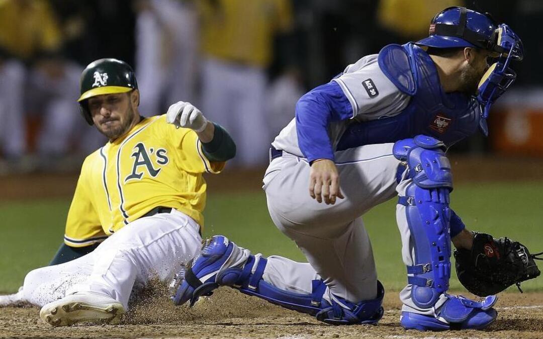 The A’s Matt Joyce slid past Royals catcher Drew Butera and scored on a single by Marcus Semien in the eighth inning of Tuesday’s game in Oakland, Calif. The A’s scored six times in the inning and won 10-8.