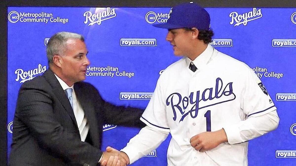 Kansas City Royals general manager Dayton Moore shakes hands with 2017 first-round draft pick Nick Pratto.
