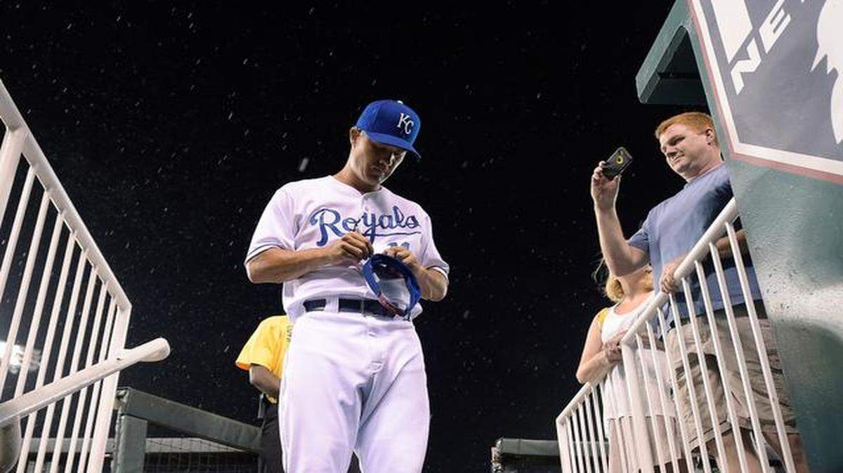 
Sunday night’s game between the Royals and the Cleveland Indians was delayed and eventually suspended in the middle of the 10th inning when heavy rain moved into the area of Kauffman Stadium. The Indians had just taken a 4-2 lead. Pitcher Jeremy Guthrie signed autographs for fans as the rain fell.
