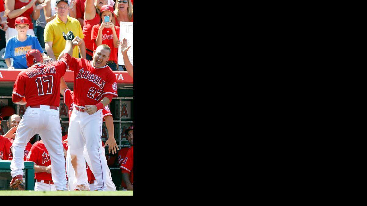 Angels outfielder Mike Trout (right) was pumped up after teammate Chris Iannetta’s solo home run broke a tie in the eighth inning on Sunday. <252><137>Los Angeles Angels’ Mike Trout (27) congratulates Chris Iannetta (17) for hitting a solo home run against the Kansas City Royals in the eighth inning of a baseball game on Sunday, May 25, 2014, in Anaheim, Calif. The Angels won 4-3. (AP Photo/Alex Gallardo)<252><137>