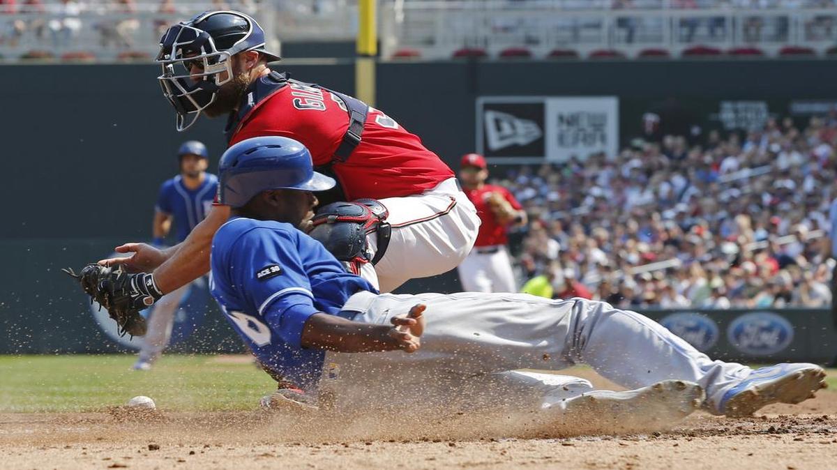 The Royals’ Lorenzo Cain slid safely past Twins catcher Chris Gimenez, who couldn’t handle the throw to the plate in the fourth inning of Sunday’s game in Minneapolis.