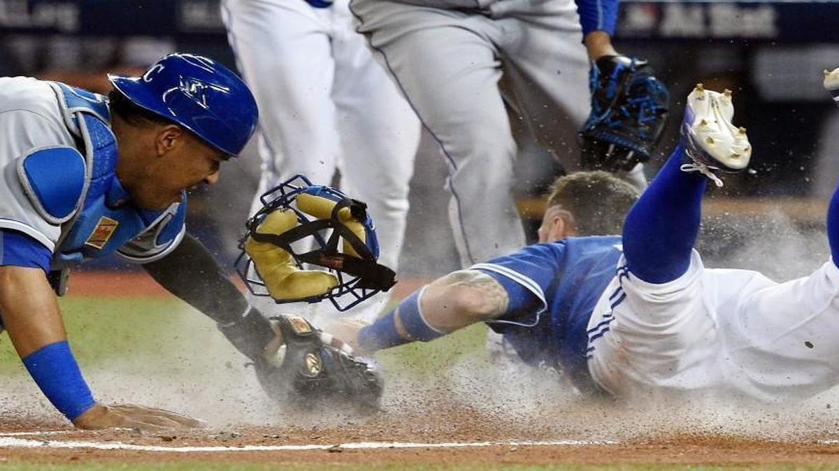 Blue Jays center fielder Kevin Pillar dives for home plate past Royals catcher Salvador Perez to score in the second inning off a two RBI hit by second baseman Ryan Goins during Monday's ALCS baseball game at Rogers Centre in Toronto.