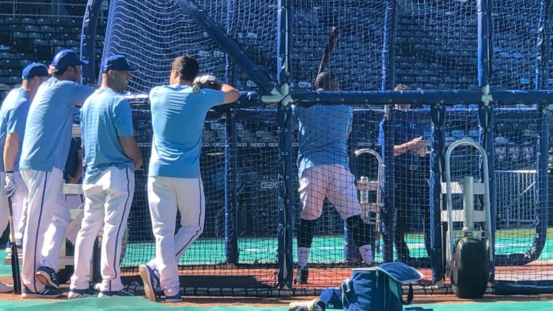 Alec Zumwalt, second from right outside batting cage, smiles while talking to the Royals’ Whit Merrifield as Carlos Santana hit during batting practice before a home game on May 16, 2022 at Kauffman Stadium. Zumwalt was named Royals hitting coach before Monday’s game.