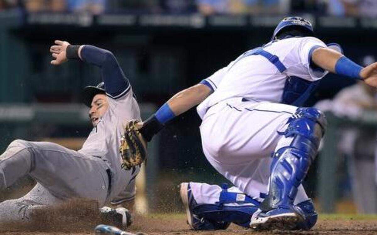 
The Yankees' Jacoby Ellsbury slides around the tag of Royals catcher Salvador Perez on a sacrifice fly by Brian McCann in the seventh inning of Monday's baseball game at Kauffman Stadium. The umpire called Ellsbury out, but that was overturned on replay review.
