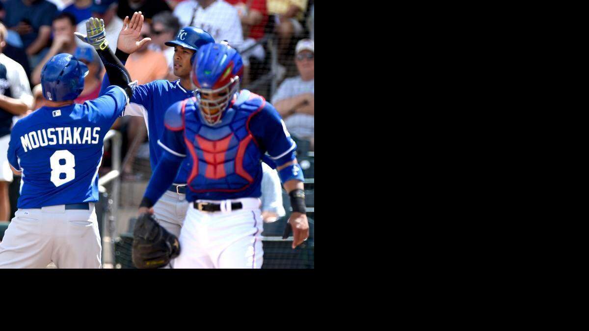 
Kansas City Royals third baseman Mike Moustakas (8) and Kansas City Royals right fielder Alex Rios (15) celebrate Moustakas grand slam in the first inning during the Kansas City Royals and Texas Rangers spring training baseball game at Surprise Stadium on Monday, March 30, 2015, in Surprise, Arizona.
