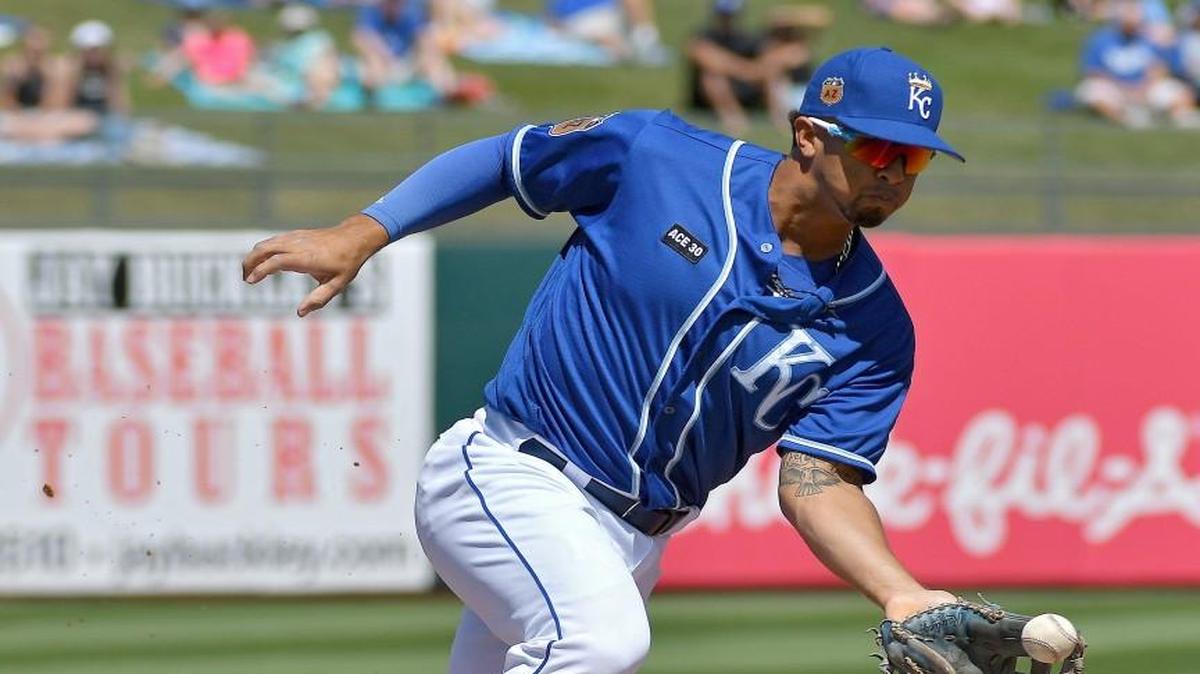 Kansas City Royals third baseman Cheslor Cuthbert grabs a groundout by Chicago White Sox's Matt Davidson in the first inning during a spring training baseball game in Surprise, Arizona.