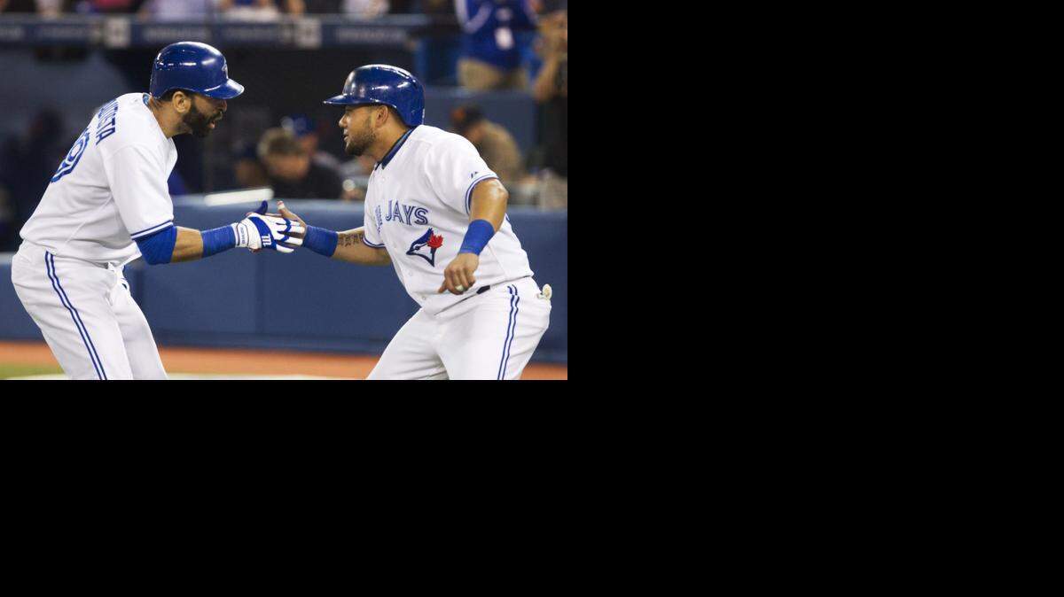 
Toronto Blue Jays' Melky Cabrera, right, congratulates teammate Jose Bautista after he hit a two-run home run off Kansas City Royals starting pitcher James Shields during first inning of a baseball game, Thursday, May 29, 2014, in Toronto. 
