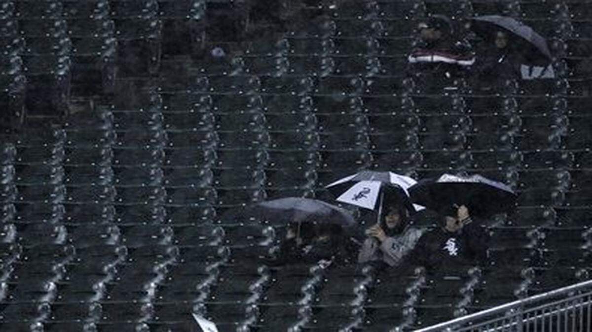 
Fans brave the rain during the seventh inning of Friday’s baseball game between the Royals and the White Sox in Chicago.
