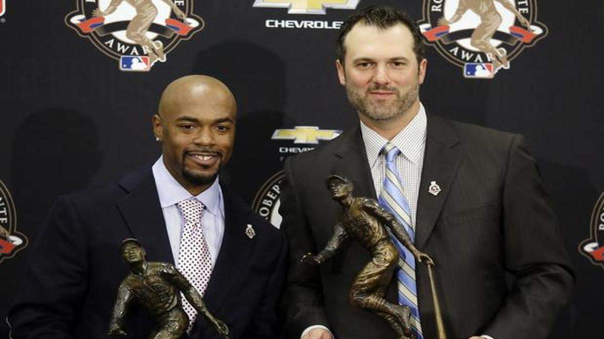 
Philadelphia Phillies shortstop Jimmy Rollins (left) and retired Chicago White Sox first baseman Paul Konerko posed with their trophies after being named co-winners of the 2014 Roberto Clemente Award.
