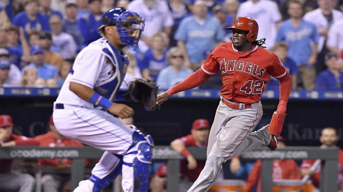 Los Angeles Angels' Cameron Maybin scores on a double by Ben Revere in the seventh inning in front of Royals catcher Salvador Perez during Saturday's baseball game at Kauffman Stadium in Kansas City, Mo.