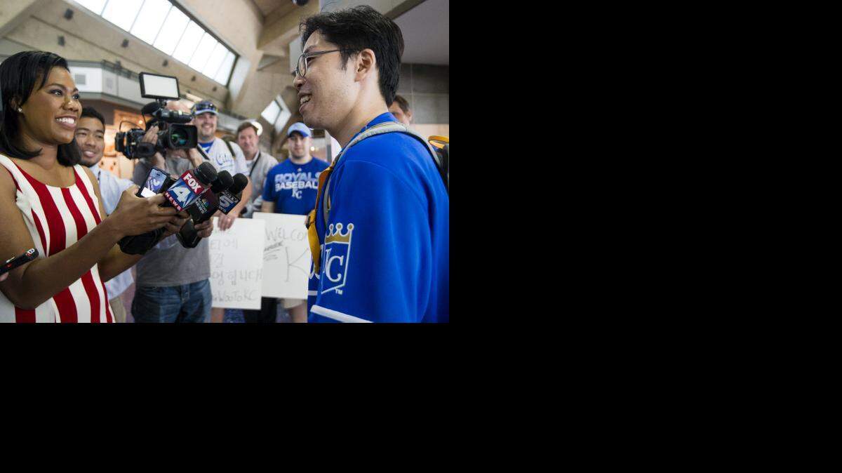 
SungWoo Lee, right, speaks to the local media after arriving at KCI. SungWoo Lee is a major Royals fan from South Korea and is traveling to Kansas City to see his first Royals game. SungWoo Lee flew into Kansas City, Missouri on Tuesday, August 5, 2014. 
