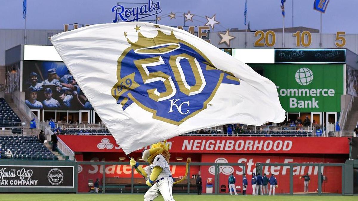Kansas City Royals mascot Sluggerrr waves the team’s 50th anniversary flag before a game against the Seattle Mariners on April 9, 2018, at Kauffman Stadium in Kansas City, Mo.