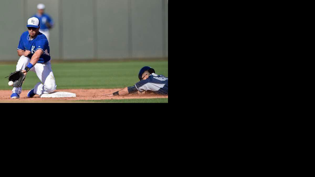 
Kansas City Royals second baseman Whit Merrifield (65) tries to catch the ball as San Diego Padres Rico Noel dives for the base to steal during the Kansas City Royals and the San Diego Padres spring training baseball game at Surprise Stadium in Surprise, Ariz., on Wednesday.
