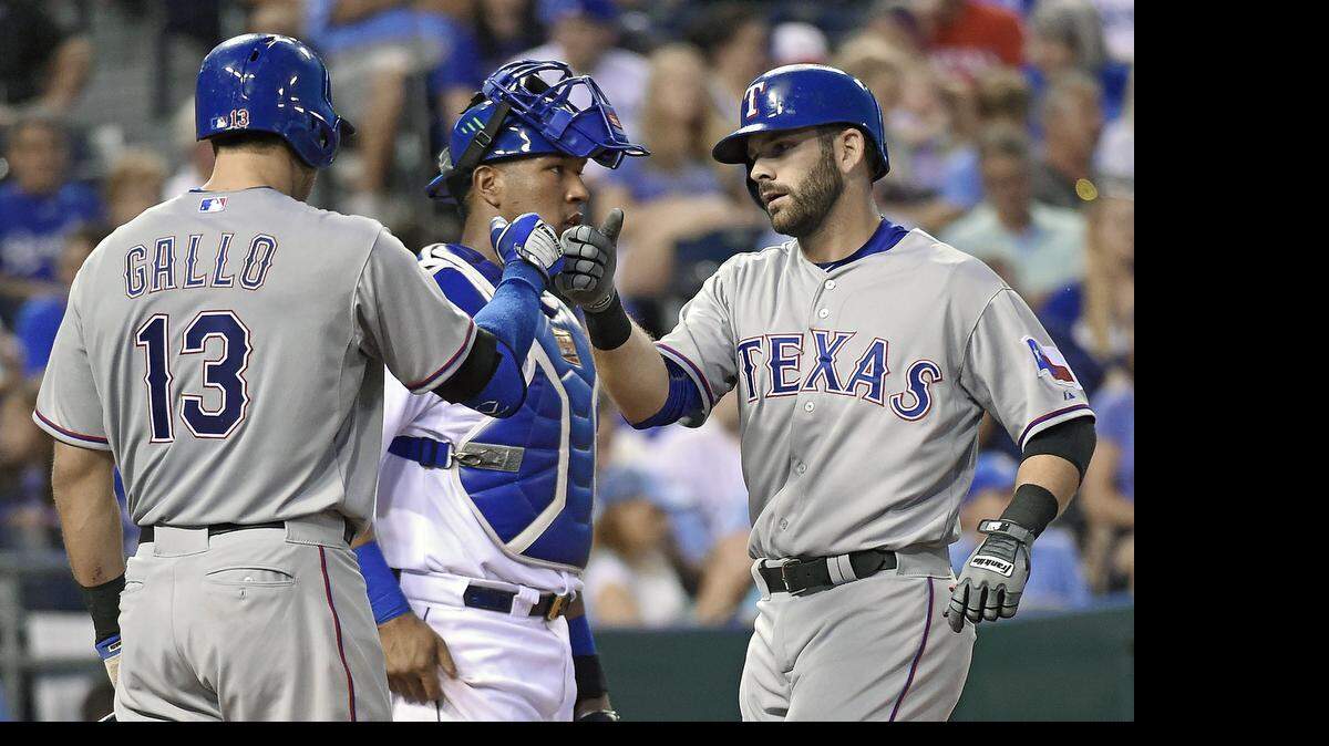 Texas Rangers' Mitch Moreland (18) is congratulated by Joey Gallo (13) in front of Kansas City Royals catcher Salvador Perez (13) after hitting a solo home run in the sixth inning during Friday's baseball game on June 5, 2015 at Kauffman Stadium in Kansas City, Mo.