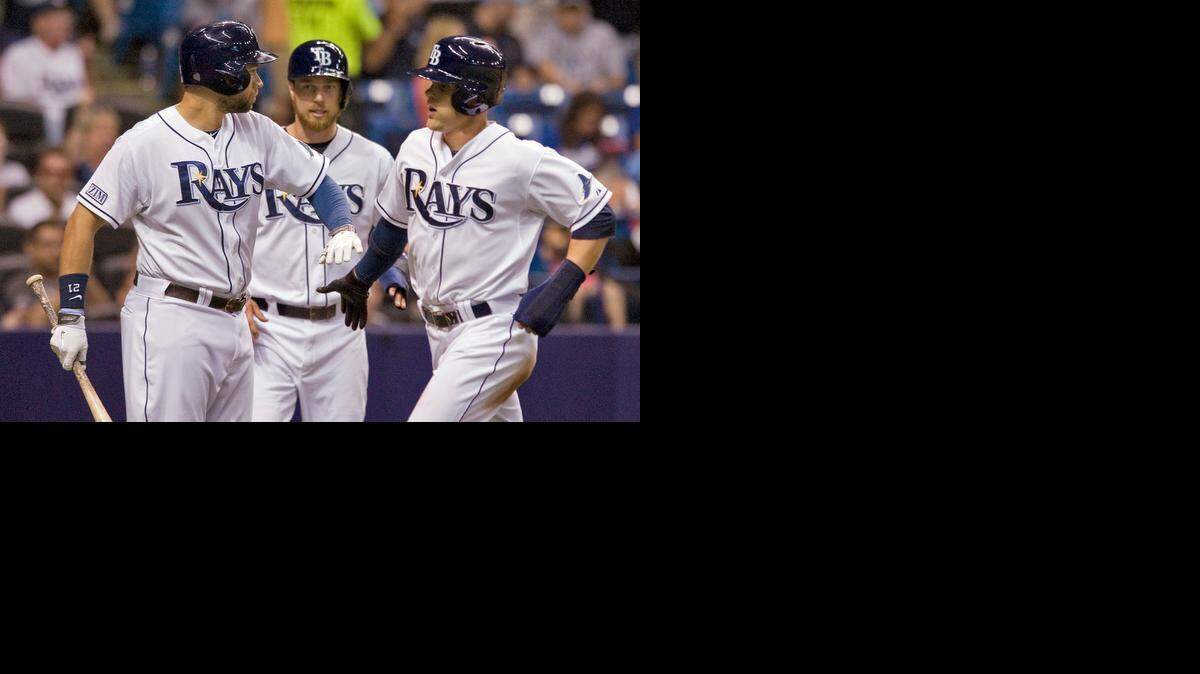 
On-deck batter James Loney (left) congratulates his Tampa Bay Rays teammates Ben Zobrist (center) and Brandon Guyer after they scored on Evan Longoria's two-run single in the sixth inning against the Kansas City Royals on Tuesday night in St. Petersburg, Fla.
