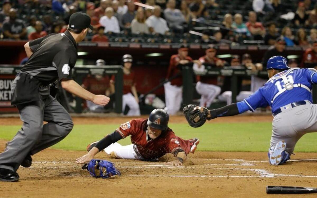 The Diamondbacks' A.J. Pollock avoids a tag from Royals catcher Salvador Perez to score on a hit by David Peralta during the third inning of Friday’s spring training baseball game in Phoenix.