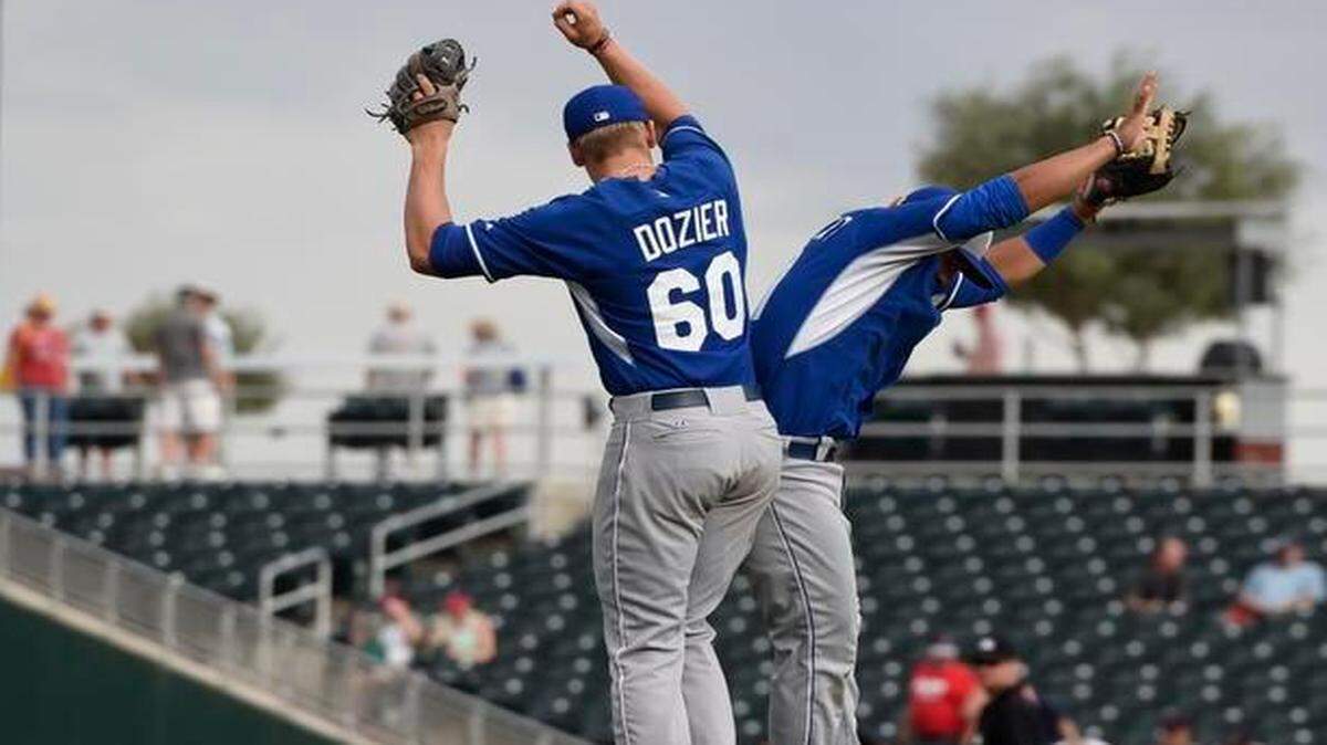 
Royals infielders Hunter Dozier (60) and Cheslor Cuthbert jump into the air Thursday to celebrate Kansas City’s 10-5 win over the Cleveland Indians spring training baseball game in Goodyear, Ariz.

