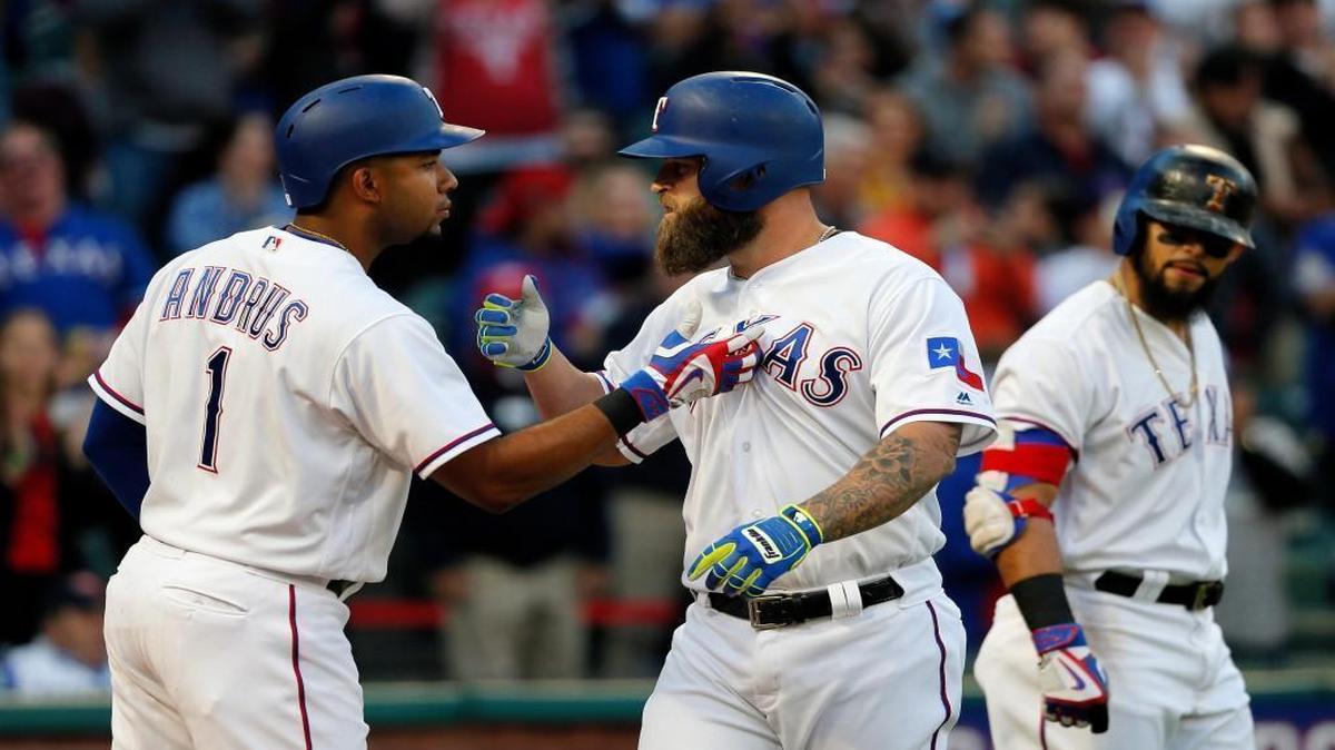 Texas Rangers' Elvis Andrus, left, and Mike Napoli, center, celebrate Napoli's solo home run as Rougned Odor, right, watches in the second inning Saturday against the Kansas City Royals in Arlington, Texas.