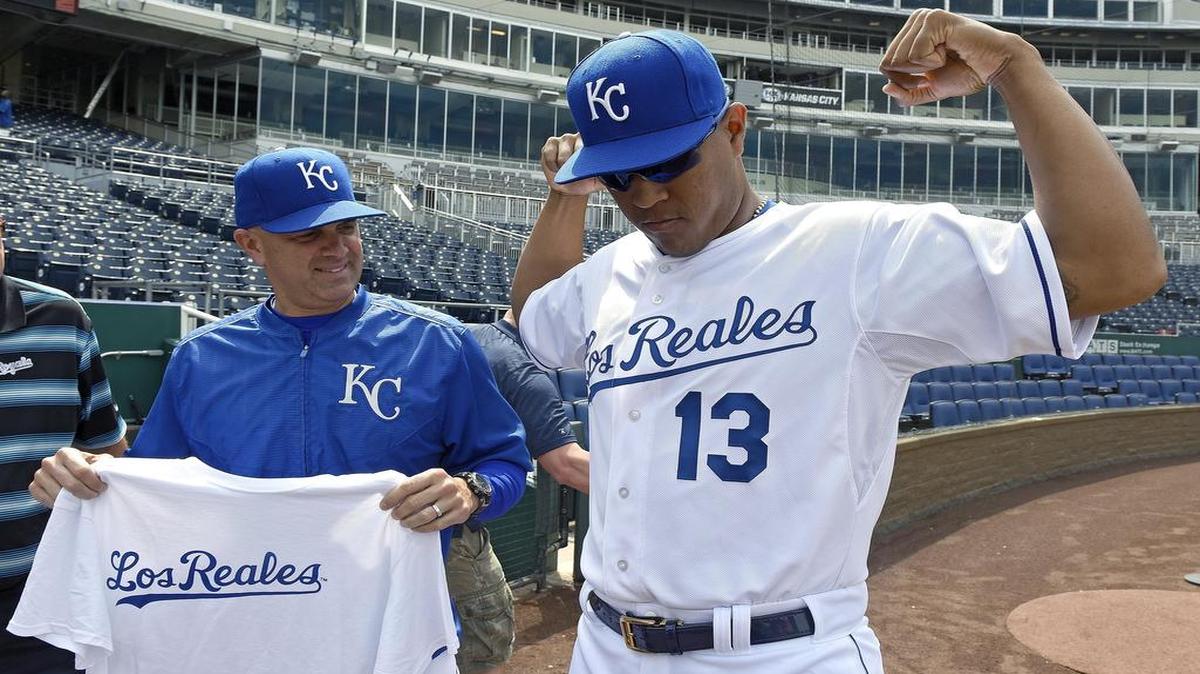
Royals coach Pedro Grifol, left, and Salvador Perez show off the club’s “Los Reales” T-shirt and jersey before Tuesday’s game against the Indians at Kauffman Stadium. The team will wear the special uniforms July 25 vs. the Astros; the T-shirts were a giveaway to the first 15,000 fans through the gates on Tuesday afternoon.
