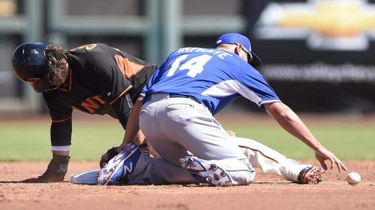 
Royals second baseman Omar Infante (right) reached for the ball after he missed a pick-off attempt on the Giants' Brandon Crawford in the second inning during Monday’s spring training baseball game in Scottsdale, Ariz.
