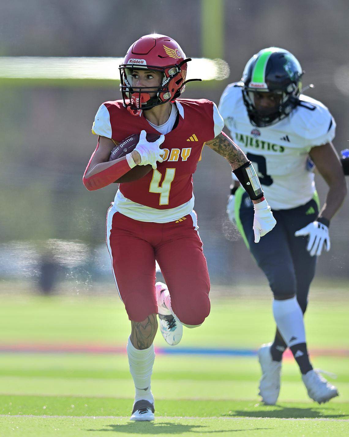 Kansas City Glory running back #4 Maria Fautali runs away from a Seattle Majestics defender on March 28. Fautali is a four-time all-league running back from Akron, Ohio.