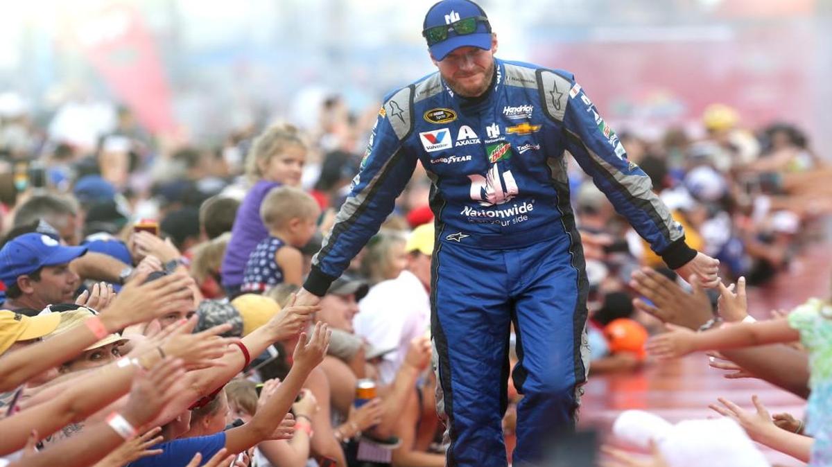 Dale Earnhardt, Jr., gets low fives during driver introductions at the Coke Zero 400 at Daytona International Speedway in July. Earnhardt, who has been dealing with concussion symptoms for months, will miss the rest of the NASCAR season.