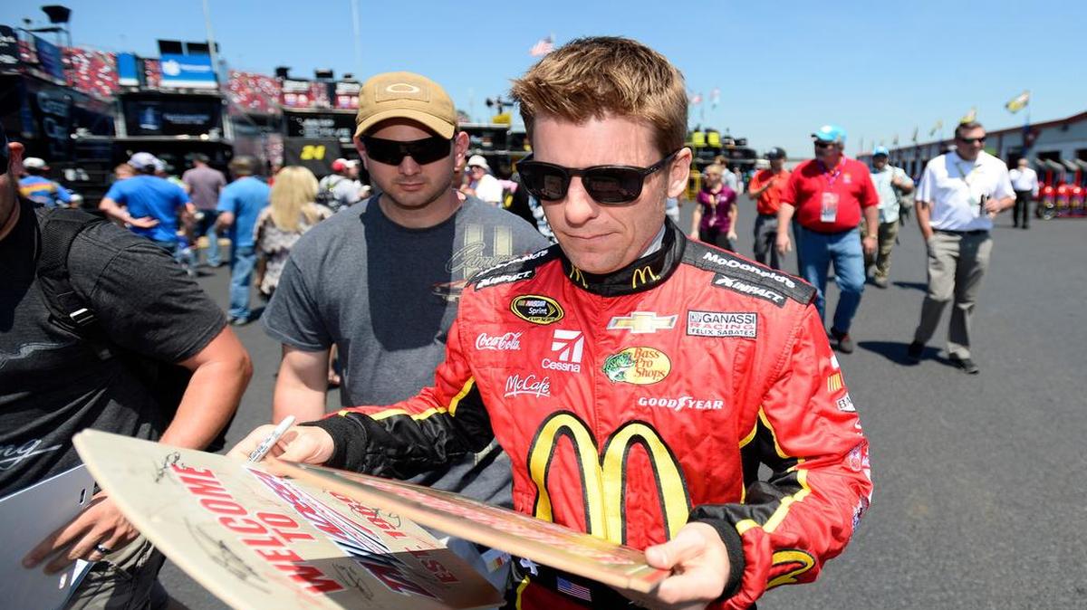 
NASCAR driver Jamie McMurray signs autographs in the garage area during qualifying for a recent race at Talladega.

