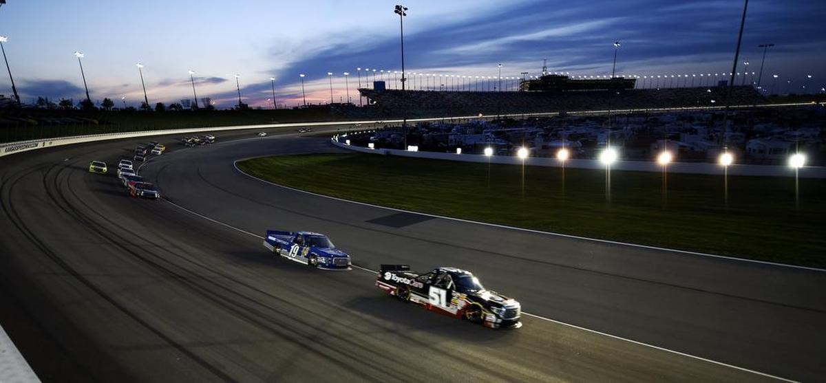 Joey Lagano (19) chased Kyle Busch (51) into turn two during the NASCAR Camping World Truck Series race on May 9, 2014, at Kansas Speedway.