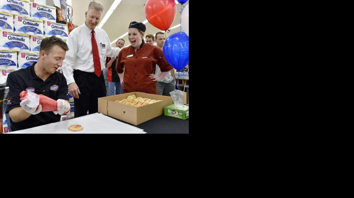 
NASCAR Sprint Cup driver A.J. Allmendinger (from left) reacts when Steve Brown, an assistant store manager, brought cake decorator Jessica Sollars to give him some tips. Allmendinger stopped by the Hy-Vee in Shawnee on Wednesday to decorate cookies, sign autographs and promote the upcoming Hollywood Casino 400 at Kansas Speedway.
