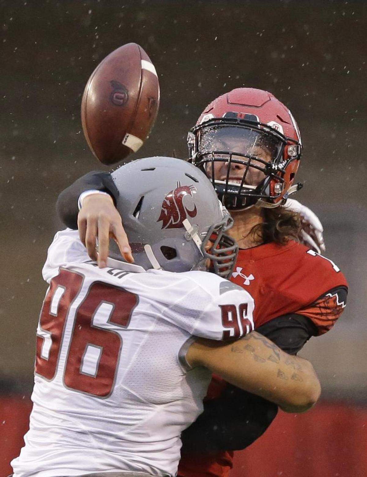 Utah quarterback Travis Wilson took a hit from Washington State defensive lineman Xavier Cooper on Saturday, Sept. 27, 2014, in Salt Lake City. Washington State won 28-27.