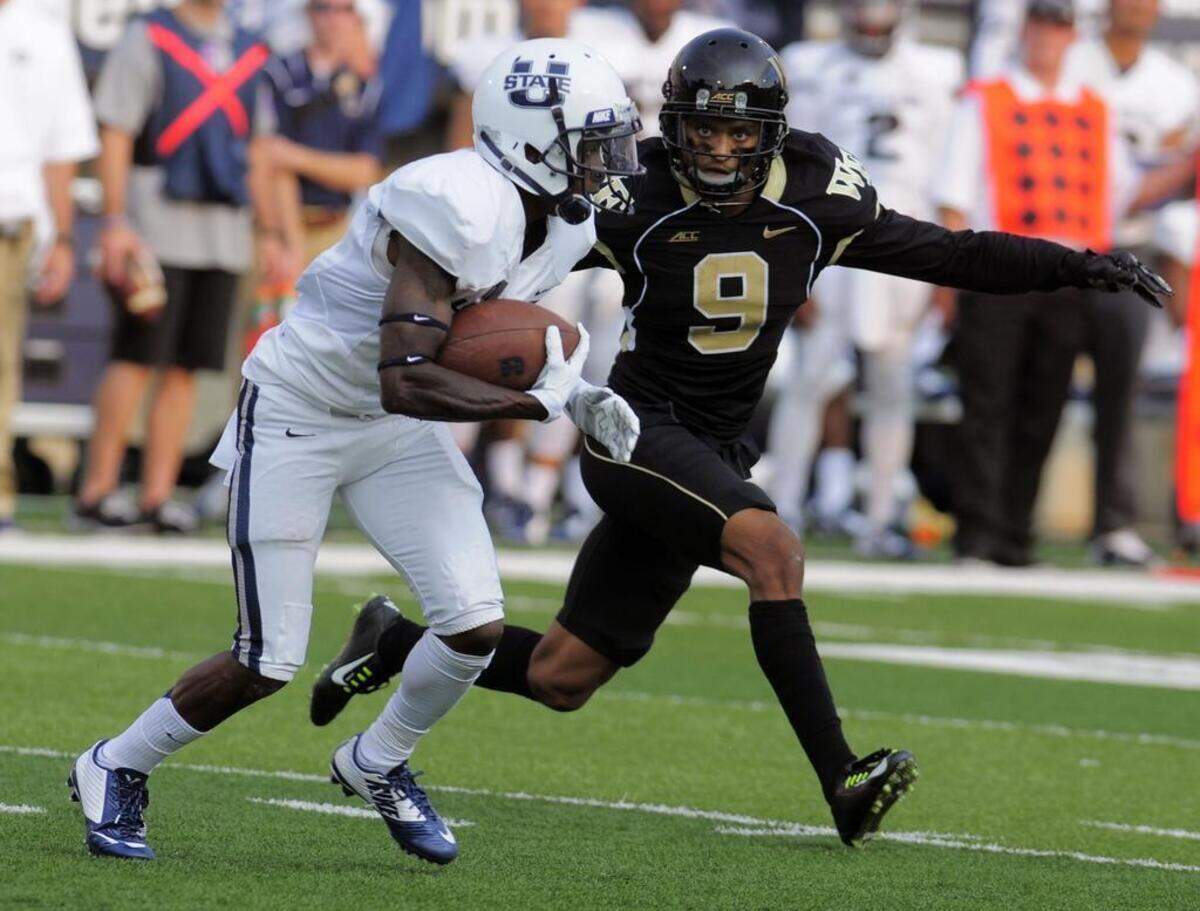 Wake Forest cornerback Kevin Johnson closed in on Utah State receiver JoJo Natson on Sept. 13, 2014, in Logan, Utah.