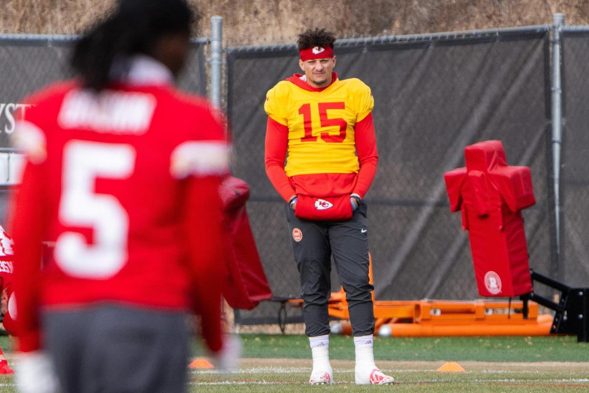 Kansas City Chiefs quarterback Patrick Mahomes stretches his injured ankle as he watches Kansas City Chiefs wide receiver Hollywood Brown warm up at Chiefs practice on Tuesday, Dec. 17, 2024.