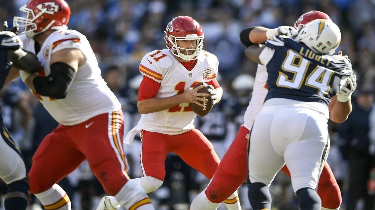 Chiefs quarterback Alex Smith (11) looked to scramble away from pressure by Chargers defensive end Corey Liuget (94) on Jan. 1 at Qualcomm Stadium in San Diego.