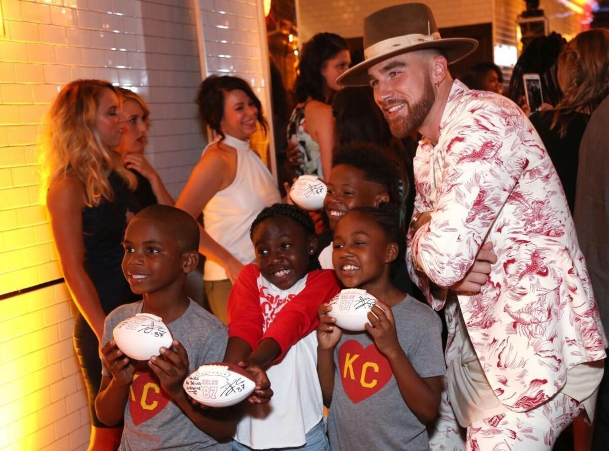 Travis Kelce poses with Amir (from left), Meziah, Amare and Ziyerra, Operation Breakthrough students who helped model during his Walk the Walk fashion benefit.