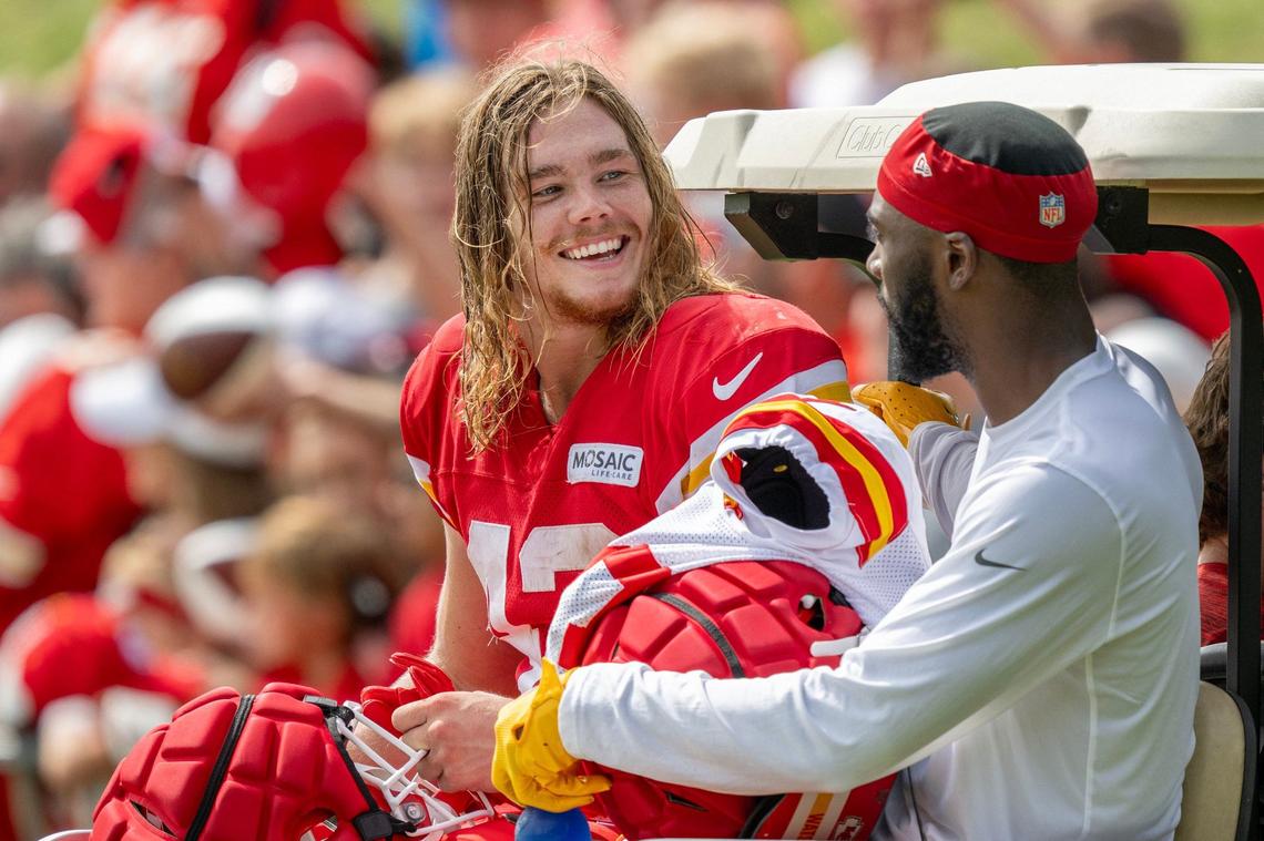 Kansas City Chiefs running back Carson Steele (42), left, and cornerback Jaylen Watson (35) are driven away in a golf cart after practice at training camp on Wednesday, Aug. 14, 2024, in St. Joseph.