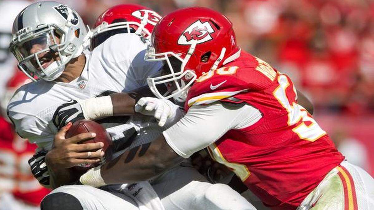 
Kansas City Chiefs outside linebacker Justin Houston (50) combined with Tamba Hali (rear) on a sack of Oakland Raiders quarterback Terrelle Pryor (2) in the fourth quarter on Oct. 13, 2013, at Arrowhead Stadium in Kansas City. The Chiefs won 24-7, improving to 6-0.
