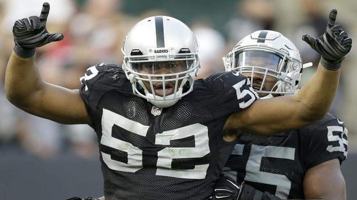 
Raiders outside linebacker Khalil Mack (52) celebrated with outside linebacker Sio Moore after Mack sacked San Francisco 49ers quarterback Colin Kaepernick in the fourth quarter Sunday in Oakland, Calif.. The Raiders won the game 24-13 and faces the Chiefs next Sunday at Arrowhead Stadium. 
