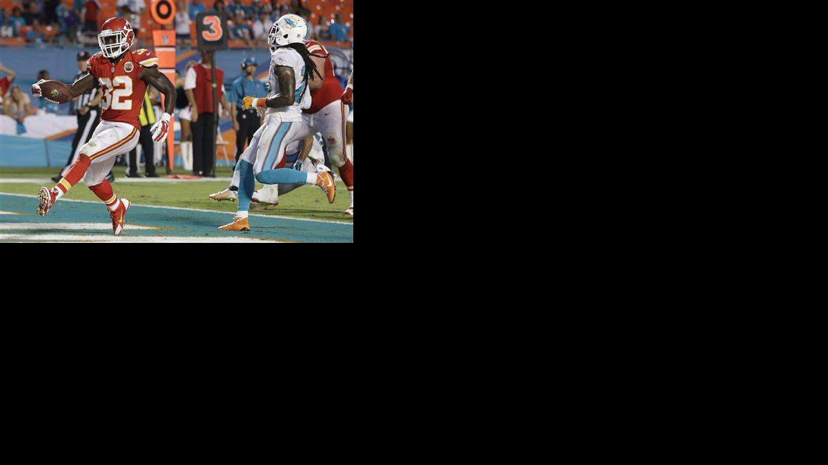 Kansas City Chiefs running back Cyrus Gray (32) scores a touchdown past Miami Dolphins cornerback Will Davis, right, during the second half of an NFL football game, Sunday, Sept. 21, 2014, in Miami Gardens, Fla. The Chiefs defeated the Dolphins 34-15.