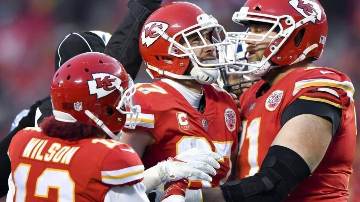 Chiefs tight end Travis Kelce, middle, needed help staying upright after a hard, helmet-to-helmet hit during the first half of Saturday’s playoff game against Tennessee.
