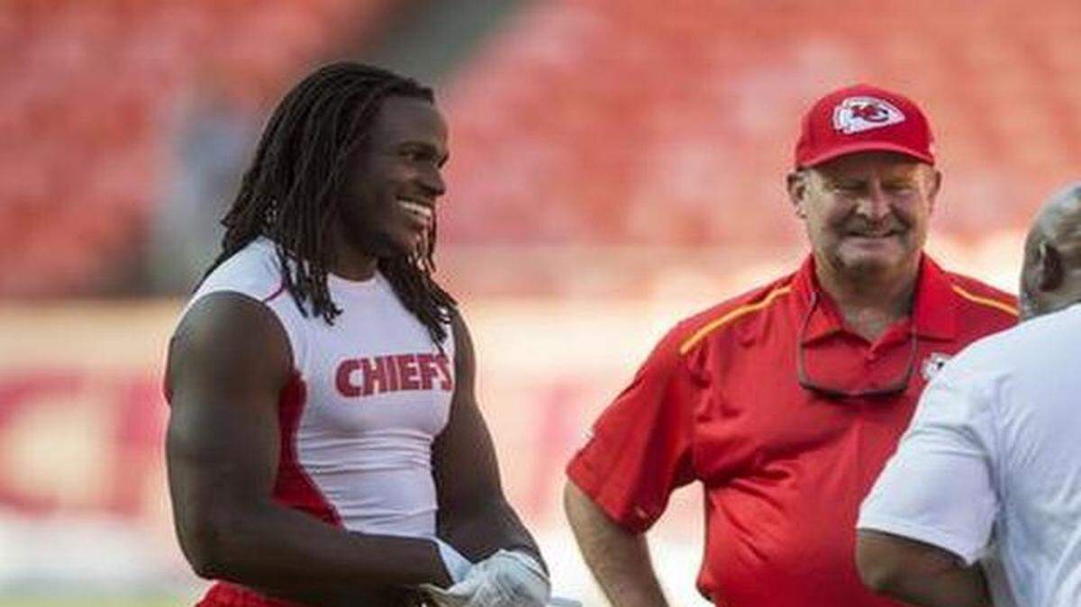 Kansas City Chiefs running back Jamaal Charles, left, spoke with Minnesota Vikings running back Adrian Peterson, right, with Chiefs assistant head coach Brad Childress, a former head coach of the Vikings, center, and Chiefs running backs coach Eric Bieniemy (in white shirt) prior to the game between the Kansas City Chiefs and the Minnesota Vikings in NFL preseason action on August 23, 2014 at Arrowhead Stadium in Kansas City, Mo.