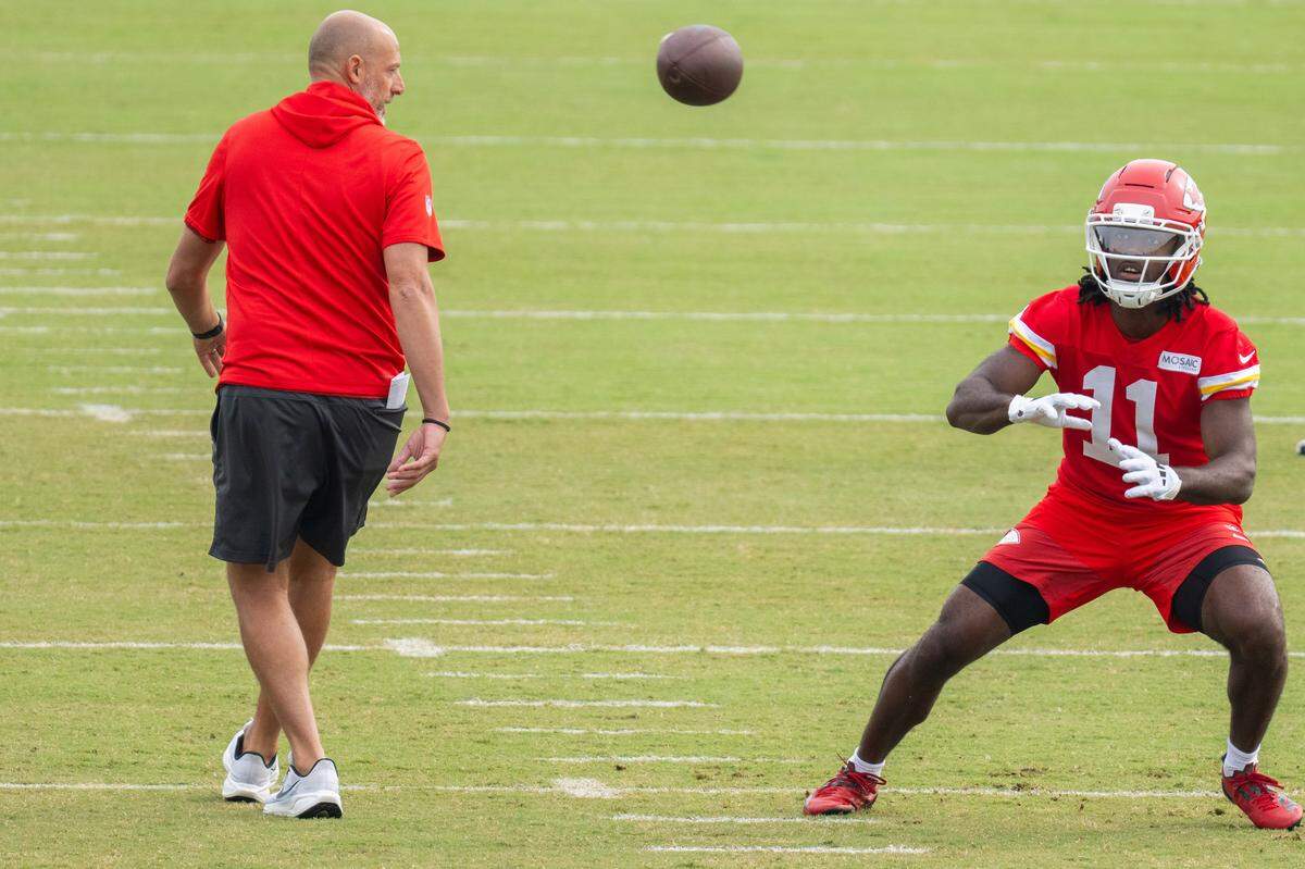 Kansas City Chiefs wide receiver Jalen Royals (11) catches a pass as Chiefs offensive coordinator Matt Nagy monitors his technique during practice drills at Chiefs Training Camp on Sunday, Aug. 3, 2025 in St. Joseph.
