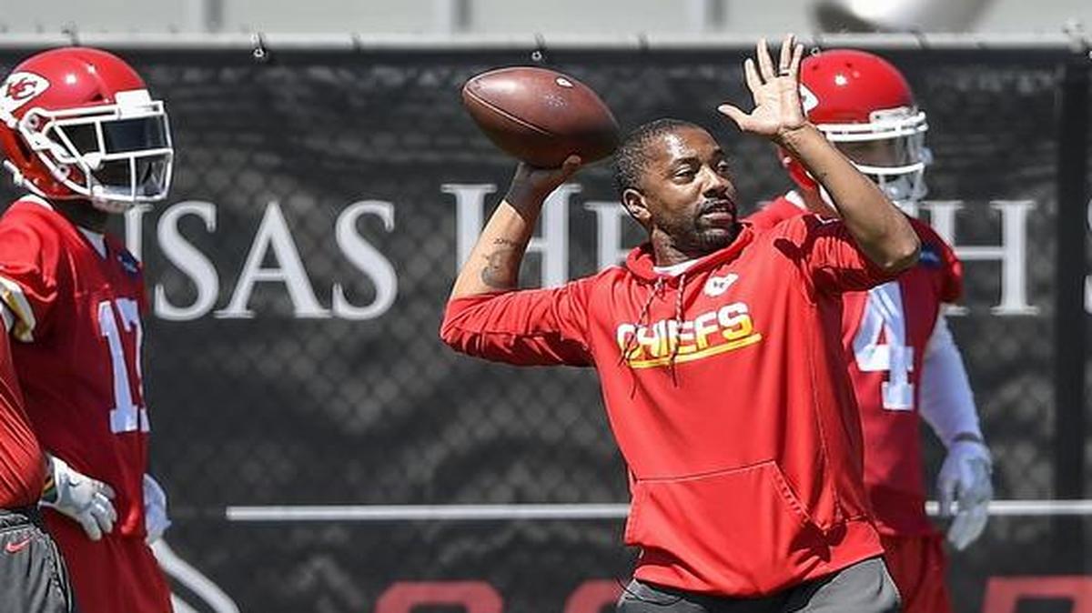 Kansas City Chiefs wide receivers coach Greg Lewis (second from right) threw practice passes to his players during a voluntary offseason session Thursday at the Arrowhead Stadium practice facility.