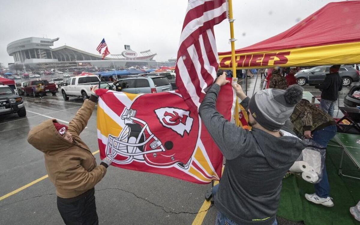 Tailgating fans put up a flag pole as they tailgated before the Chiefs’ AFC Divisional playoff game against the Pittsburgh Steelers at Arrowhead Stadium.