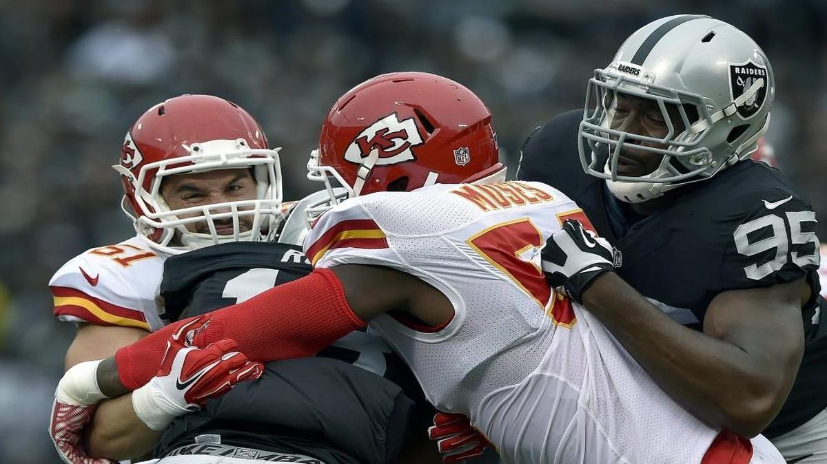 Dezman Moses (center) tackled Oakland Raiders kick returner Jeremy Ross during a game last year.