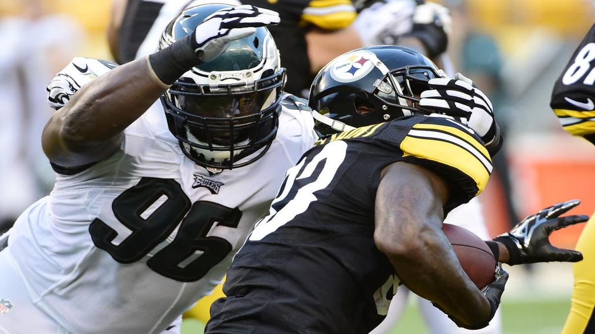 Pittsburgh Steelers running back Fitzgerald Toussaint was grabbed on the face mask by Philadelphia Eagles nose tackle Bennie Logan (left) during the first half of an NFL preseason game on Aug. 18, 2016.