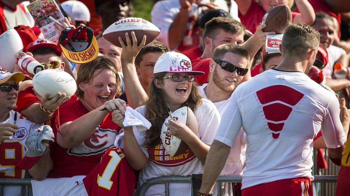 Mica Stiffler of Wichita got a hug from Kansas City Chiefs quarterback Alex Smith (right) following a 2015 training camp practice at Missouri Western State University in St. Joseph.
