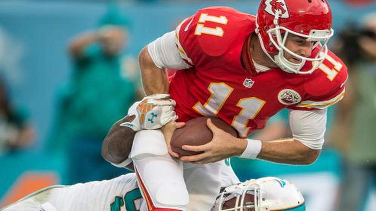 
Kansas City Chiefs quarterback Alex Smith was sacked for a safety by Miami’s Jelani Jenkins (bottom) and Randy Starks on Sunday.
