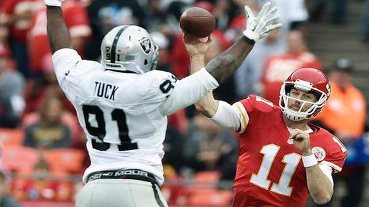 
Chiefs quarterback Alex Smith (11) threw a 37-yard pass over Oakland Raiders defensive end Justin Tuck (91) to wide receiver Dwayne Bowe in the second quarter Sunday at Arrowhead Stadium. The Chiefs won the game 31-13.
