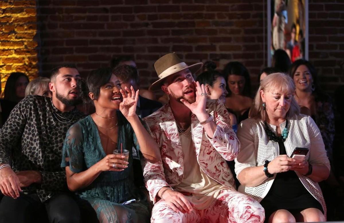 Ross Travis (from left), Kayla Brown, Travis Kelce and Kelce’s mother, Donna Kelce, cheer on models as they showcase fashions from local brands Etiquette Boutique, the Garment District, Houndstooth and Charlie Hustle.